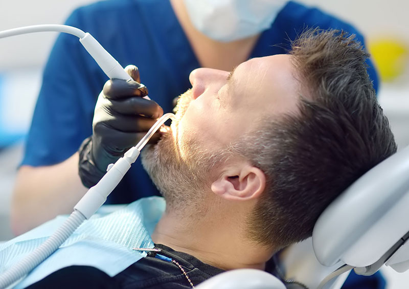 Uomo con parodontite mentre effettua una seduta dal dentista